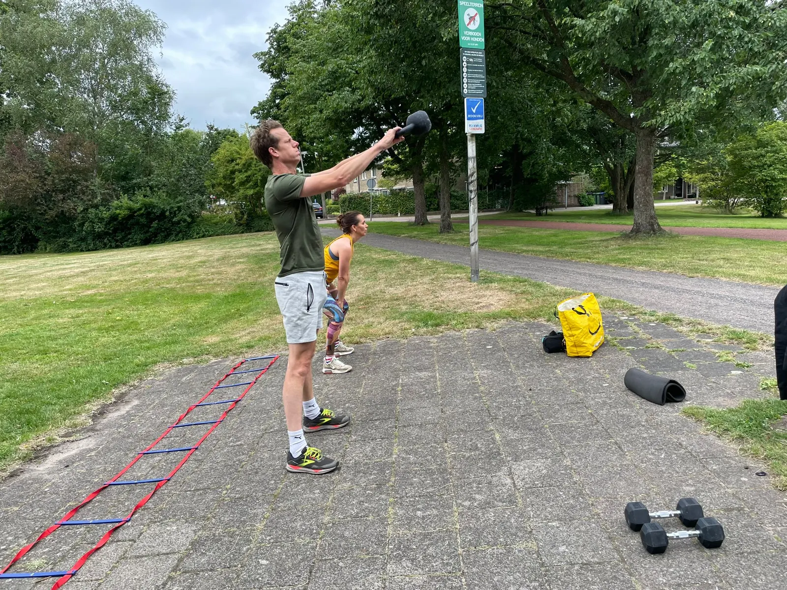 Personal trainer geeft een training met medicijnbal in het park